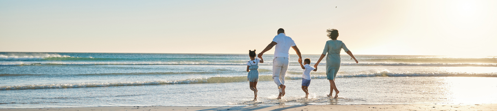 Family running into ocean