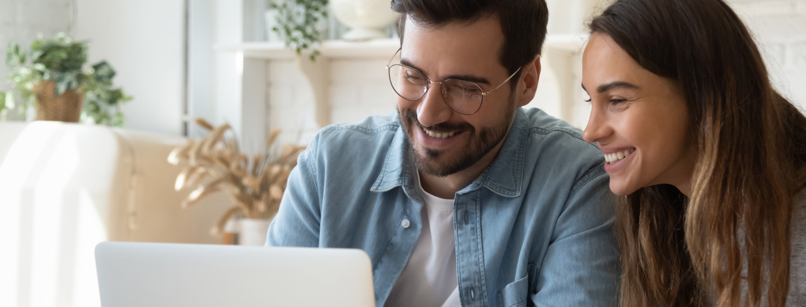 Man and woman smiling at a laptop