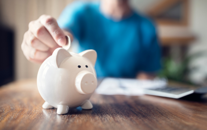 Person putting money into a piggy bank